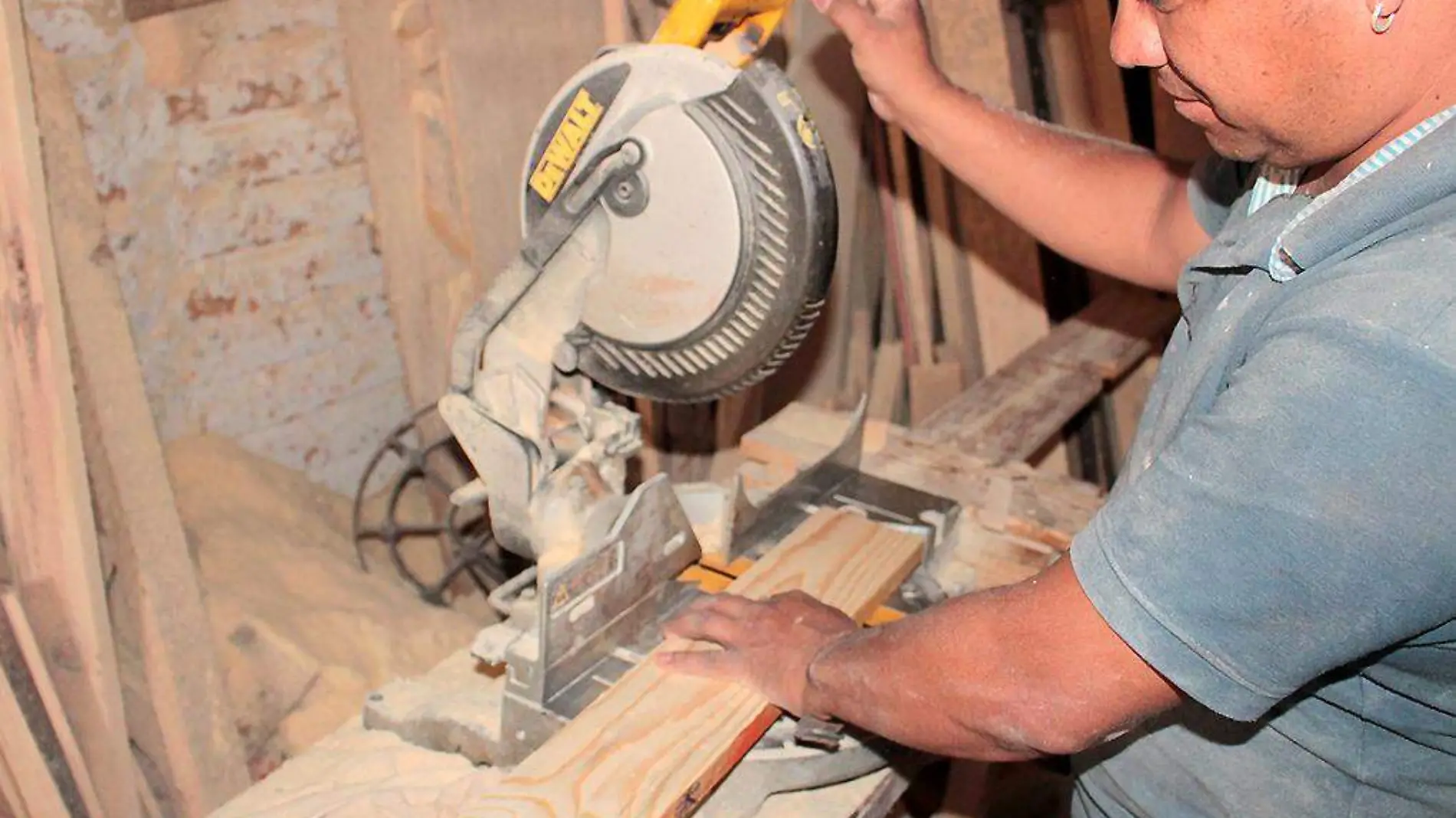 Hombre trabajando madera con una sierra